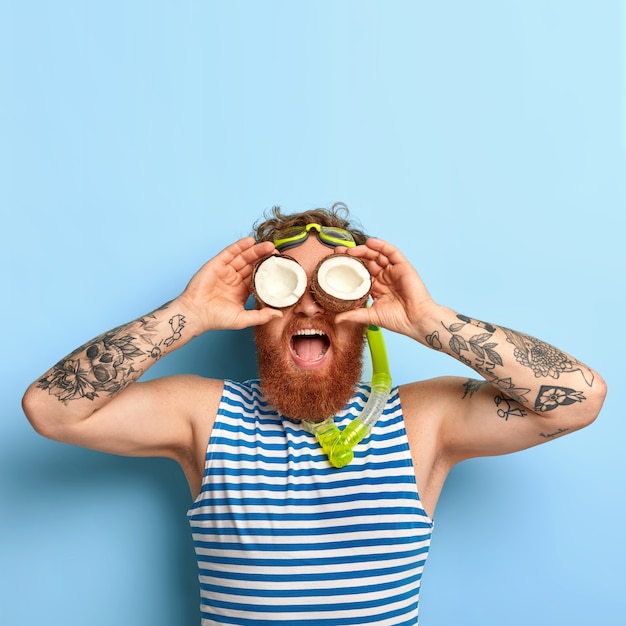 Free photo people, summer vacation, snorkeling and swimming concept. funny bearded ginger man wears snorkel mask