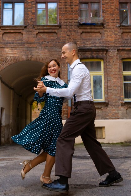 People swing dancing outdoors full shot