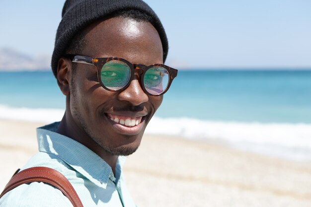 People, travel, vacations, lifestyle, tourism and happiness concept. handsome carefree relaxed male spending weekend morning on beach