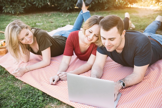 People using laptop on picnic