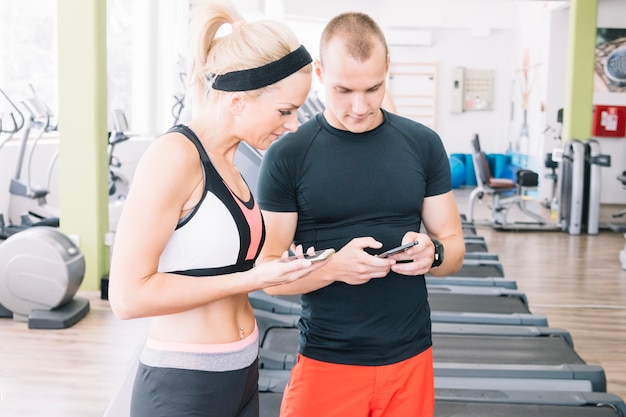 People using phones at gym