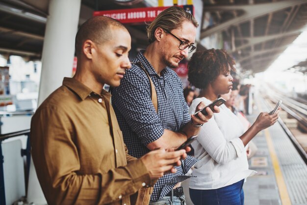 People using smartphones on the train platform