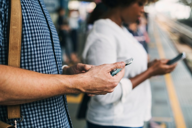 Free photo people using smartphones on a train platform