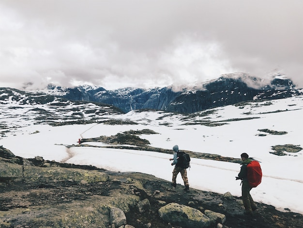 People walk across the mountains covered with snow