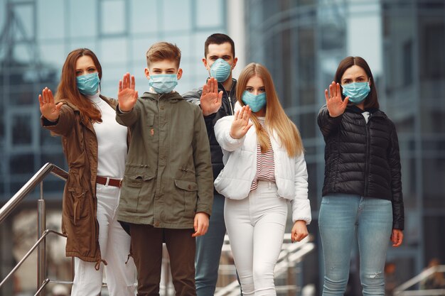 People wearing protective masks are showing stop sign by hands