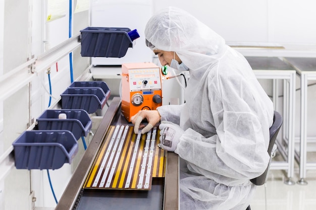 People in white isolating costumes working in laboratory