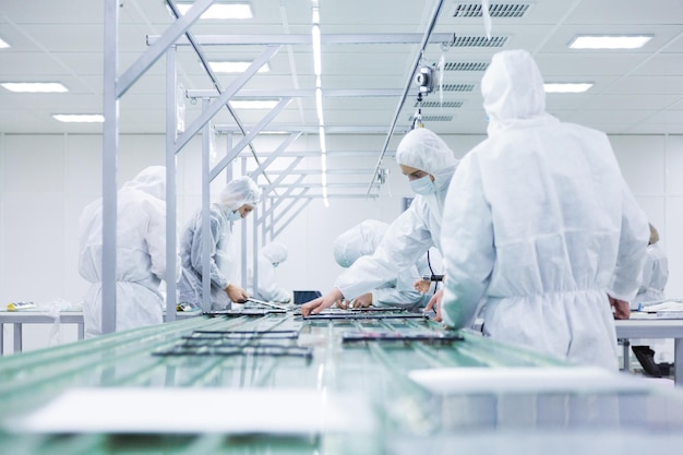 People in white isolating costumes working in laboratory