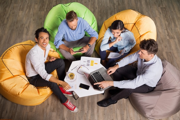 Free photo people working on beanbag chairs in trendy office