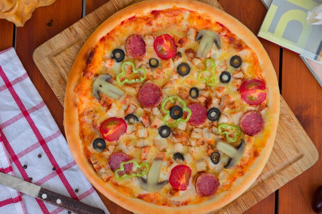 Pepperoni pizza with bell pepper, tomato slices, mushroom and olives   