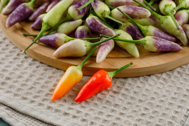 Peppers on kitchen towel and cutting board.