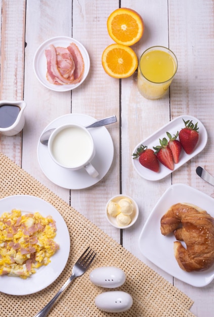 Free Photo perfect breakfast for healthy food lovers - scrambled eggs with ham, milk, coffee, a croissant