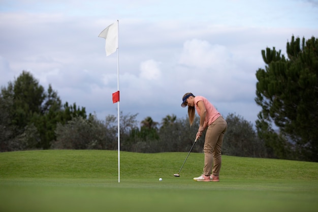 Free photo person aiming for the golf flag