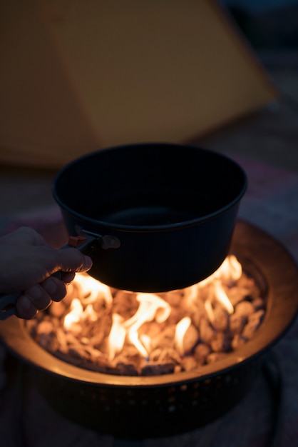 Free photo person cooking at fire camp