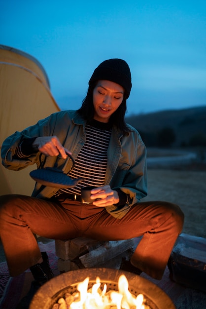 Free photo person cooking at fire camp