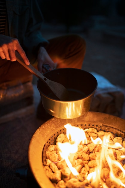 Free Photo person cooking at fire camp