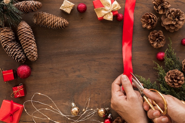 Person cutting red ribbon on wooden table