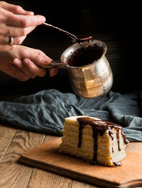 Person decorating cake with melted chocolate