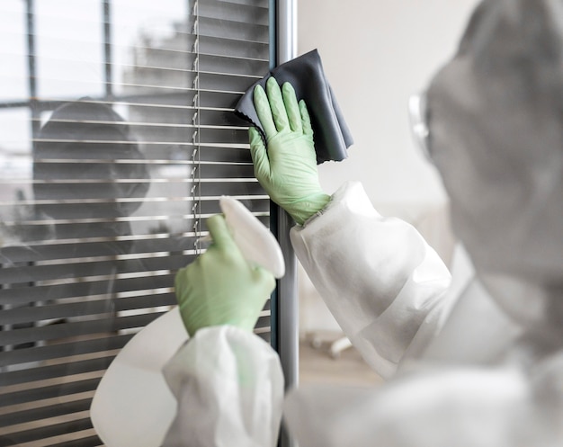 Free photo person disinfecting a dangerous area while wearing a protective suit