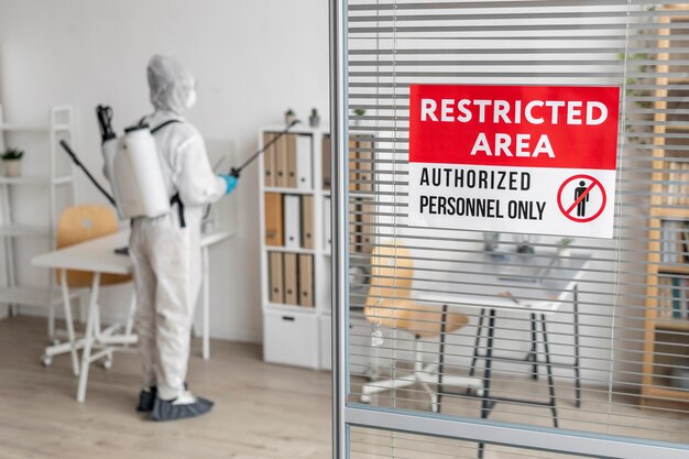 Person disinfecting a restricted area