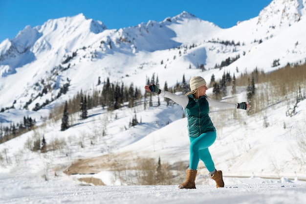 Free photo person doing yoga in cold and wintry weather