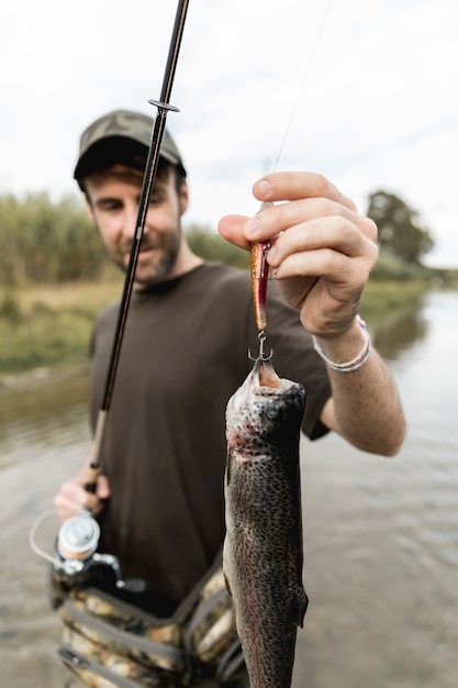 Free photo person fishing a fish with a rod