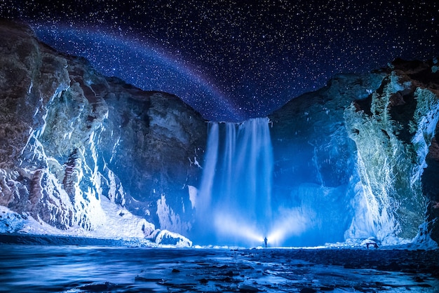 Person in front of waterfalls during nighttime