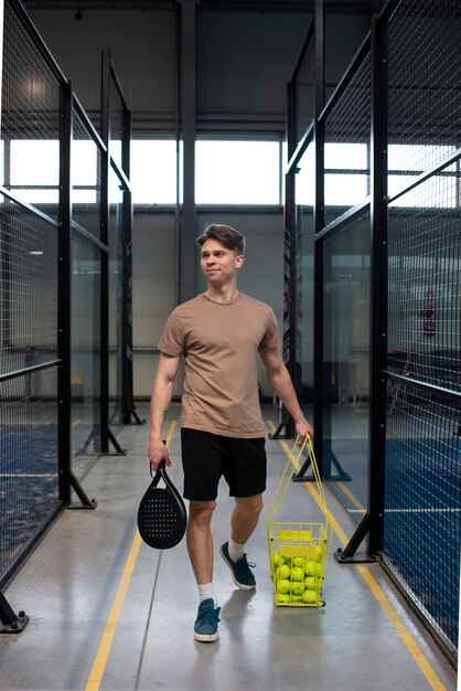 Person getting ready to play paddle tennis inside