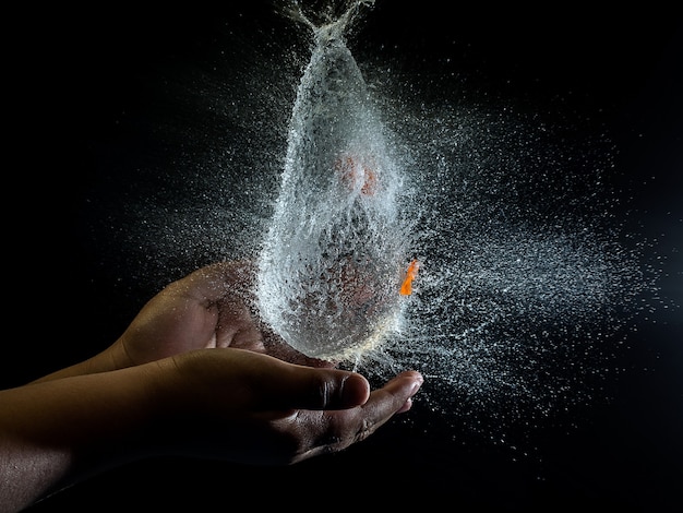 Person hands and water splashing over them