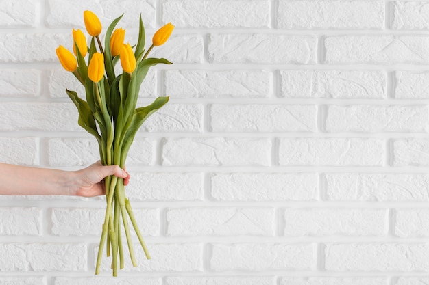 Free photo person holding a bouquet of tulips with copy space