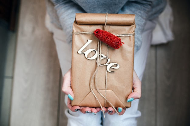 Free photo person holding brown package with word 