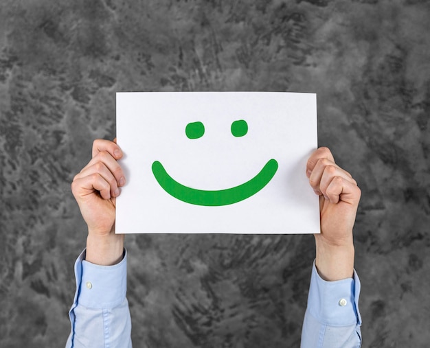 Person holding a card with a smiley face