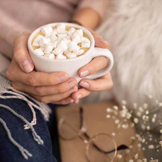 Free photo person holding cup of hot cocoa with marshmallows