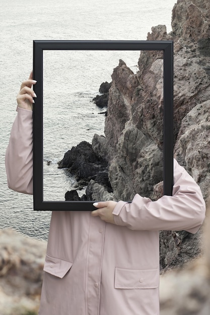 Free photo person holding frame with open nature landscape concept