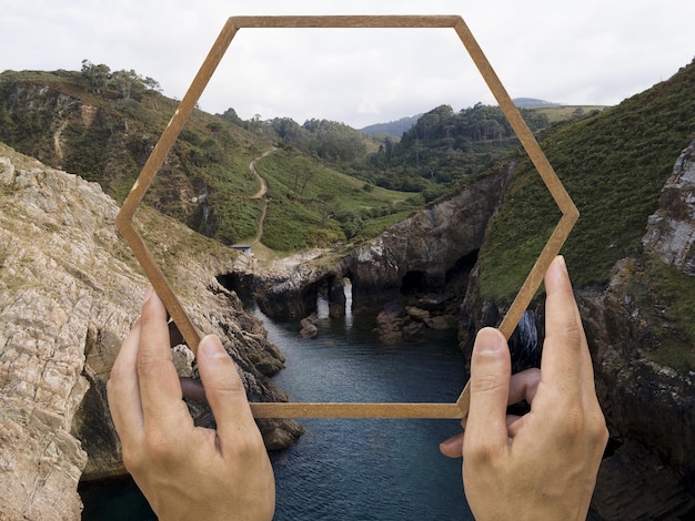 Free Photo person holding frame with open nature landscape concept