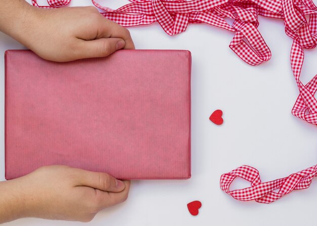 Person holding gift box on table 