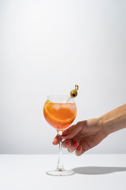 Person holding glass of refreshing cocktail drink