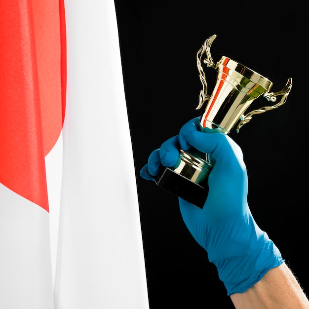 Free photo person holding a golden trophy