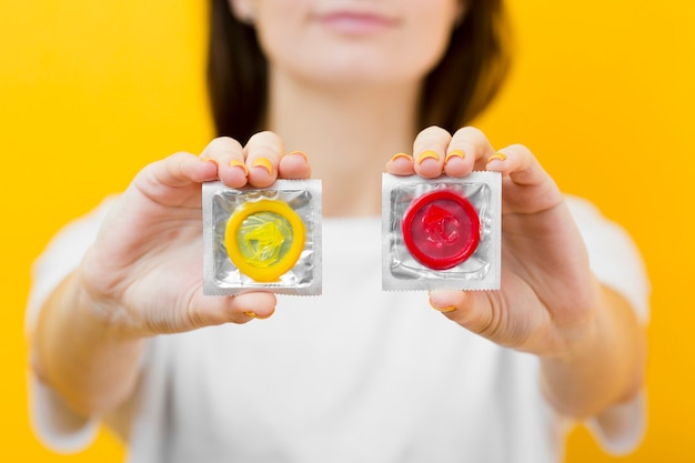 Free photo person holding in hands two condoms