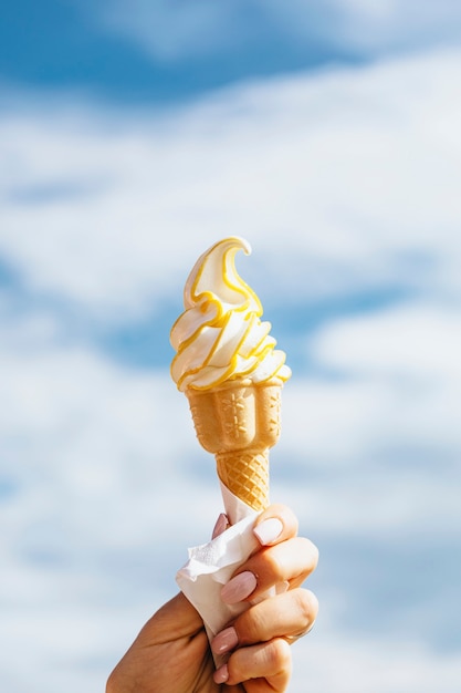 Free photo person holding ice cream in the summer time