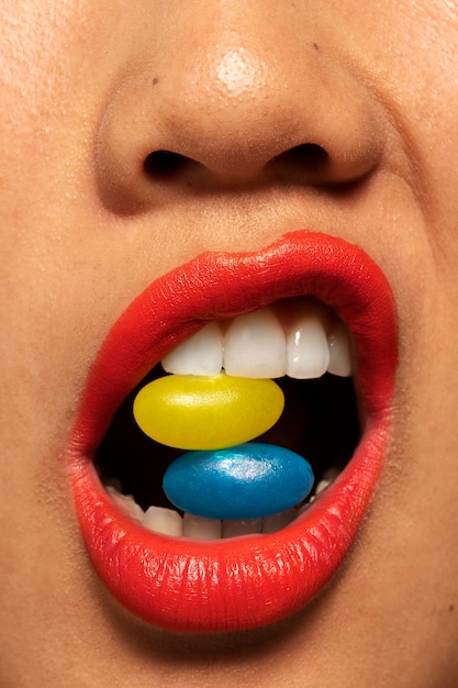 Free photo person holding jelly bean candy in their mouth