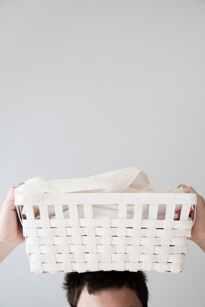 Free photo person holding laundry basket on head