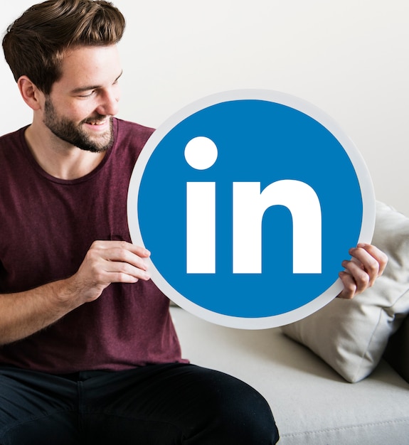 Free Photo person holding a linkedin icon