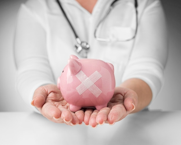 Person holding a piggy bank with band aids