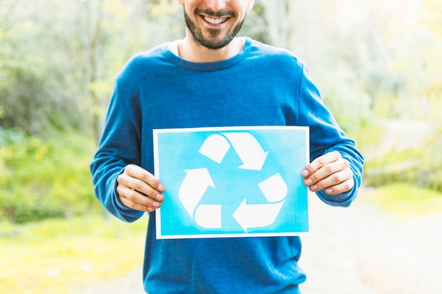 Free Photo person holding recycle sign in countryside