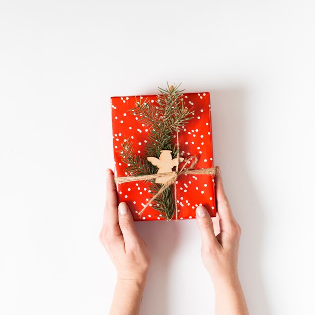 Person holding red gift box in hands