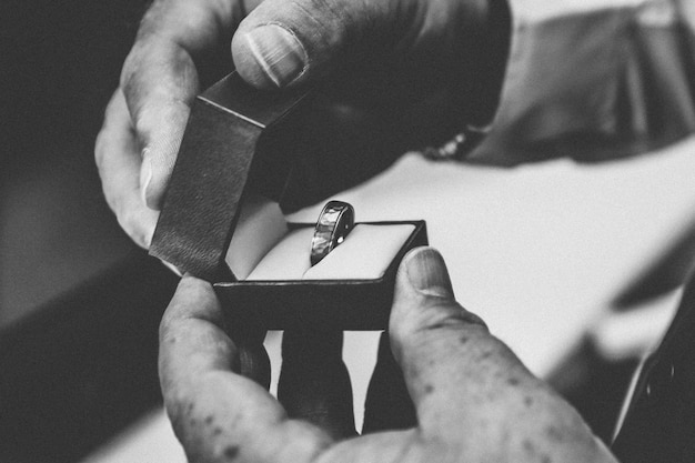 Free Photo person holding a silver ring inside of a box