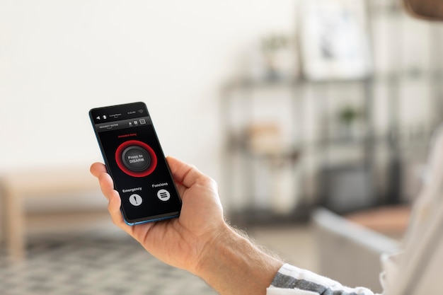 Free Photo person holding a smartphone with a home automation app