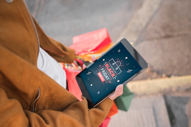 Free photo person holding a tablet with black friday search