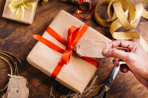 Person holding tag above gift box 