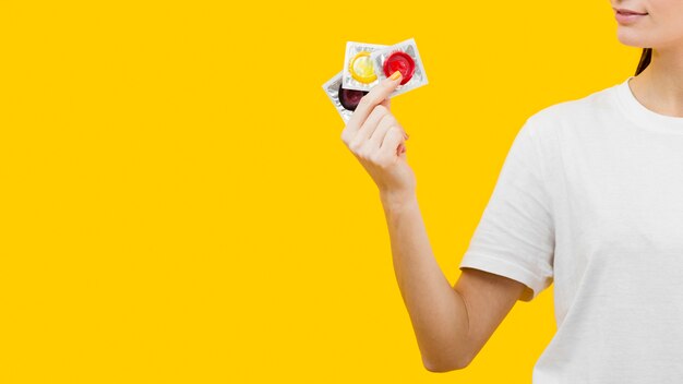 Person holding three different condoms